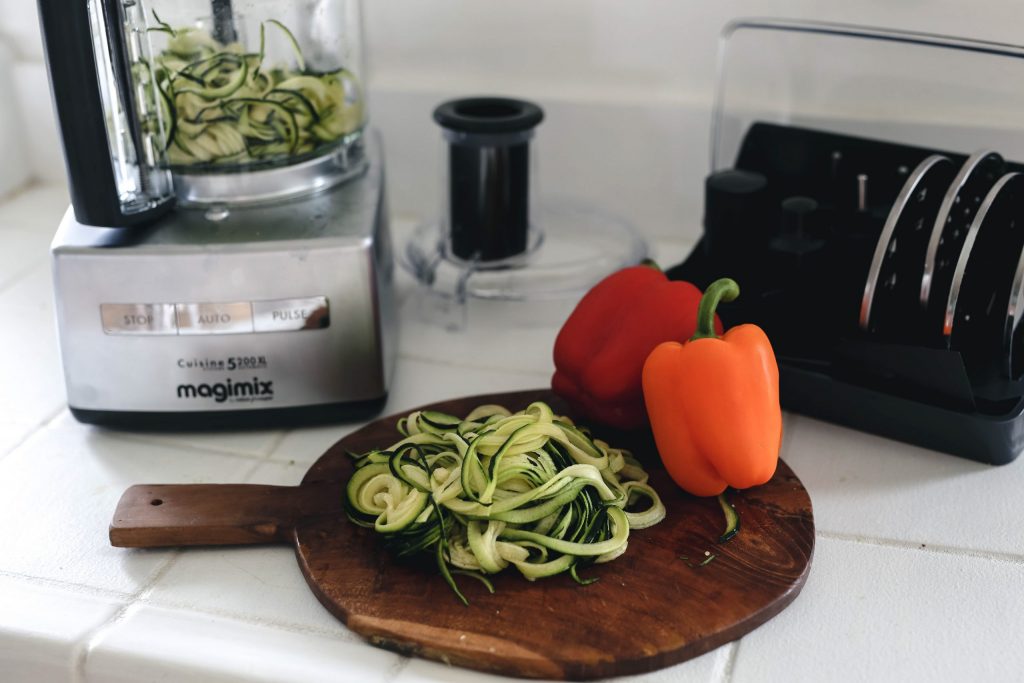 Zucchini noodles laid on a white plate.