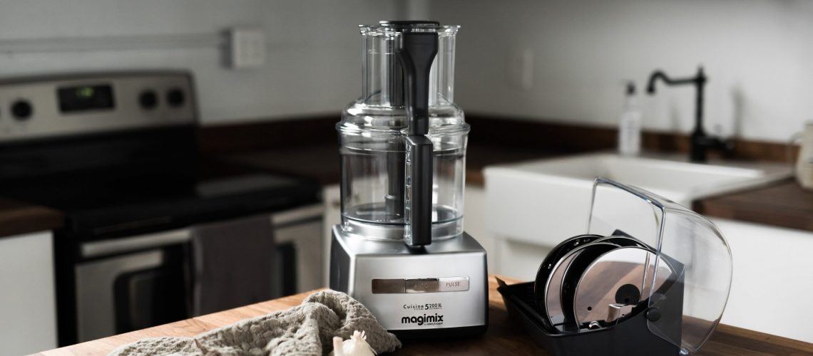 A Magimix Food Processor on a wood surface.
